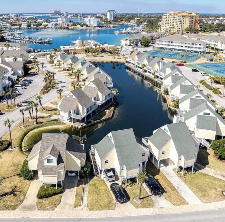 Aerial of Sandpiper Cove resort showing the lagoon, tennis courts, and Destin harbor