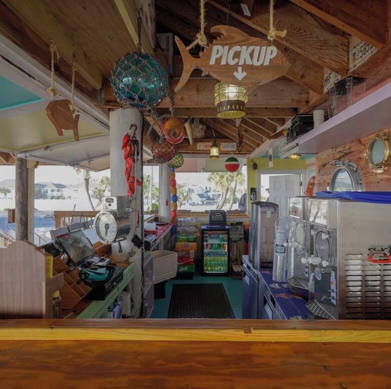 Inside Rick's SandTrap beach bar with nautical floats and a fish-shaped pickup sign