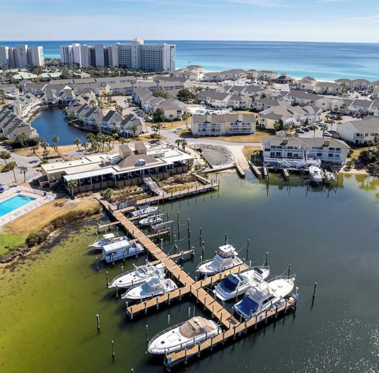 Aerial view of fishing boats docked at the Sandpiper Cove marina with the Gulf beyond